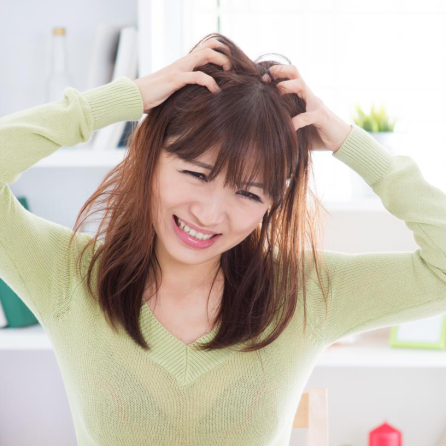 The girl is bothered by an itchy scalp